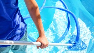 person cleaning a pool