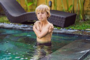 boy freezing in swimming pool