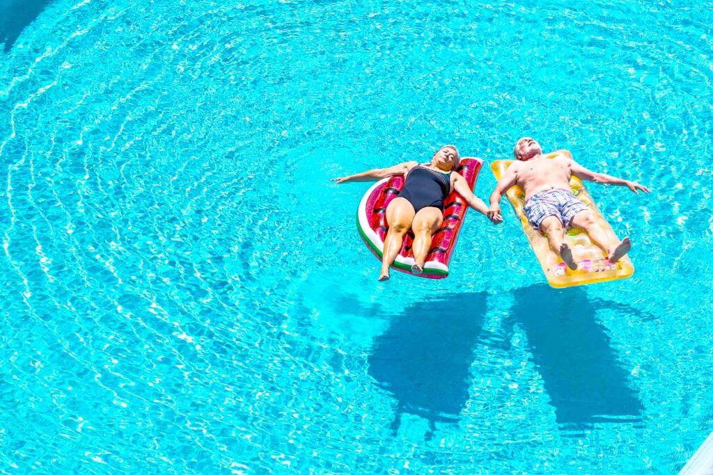 two people floating on a raft in their swimming pool