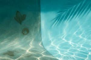pool stain removal Orlando shown by an underwater view where faint stains fade into clean plaster with sunlit ripples.