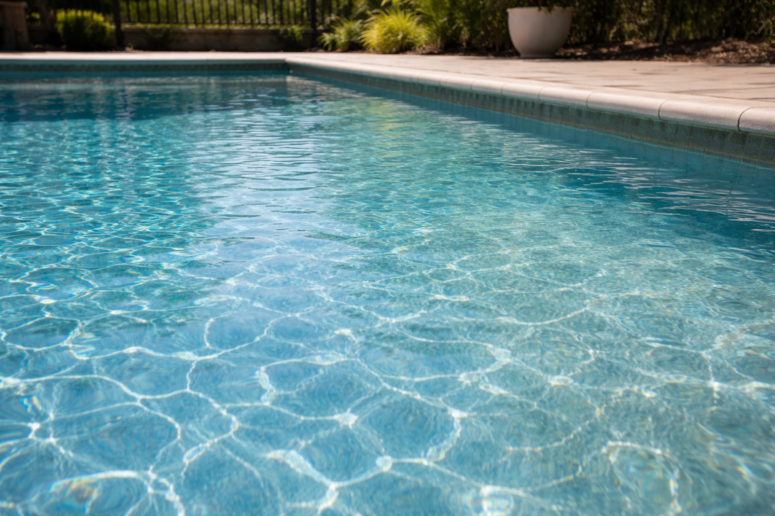 Pool chlorinator repair Orlando shown by a clean residential pool with subtle water clarity variation and strong midday sunlight reflecting across the surface.