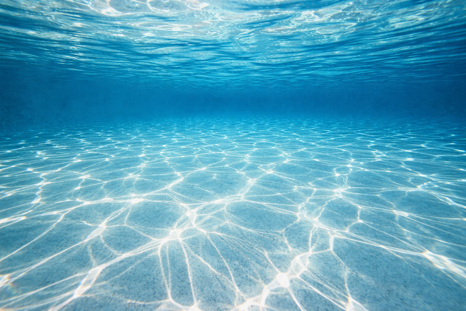 pool filter cleaning Orlando shown by bright sunlight caustic patterns moving across a clear pool floor.